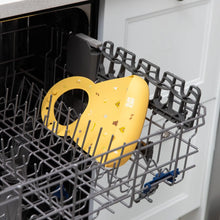 Load image into Gallery viewer, Bumkins Silicone Bib: Camp Gear sits in the top rack of an open dishwasher.