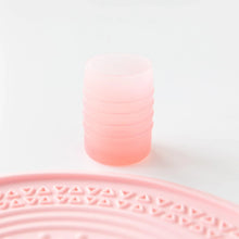 Load image into Gallery viewer, Bumkins Silicone Starter Cup: Pink sits on a white background, with a pink silicone placemat partially visible in the foreground.