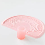Bumkins Silicone Starter Cup: Pink sits in front of a pink placemat on a white background.