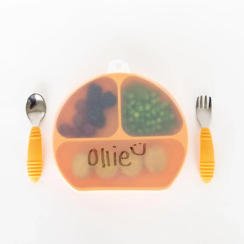 Bumkins Silicone Stretch Lid for Grip Dish 3 Section, Grip Plate with the word "Ollie" covers a plate on a white background with utensils.