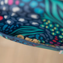 Load image into Gallery viewer, Close-up of cereal rings in the pocket of a Bumkins Starter Bib 2 Pack: Jungle & Animal Prints.