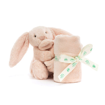 A blush-pink Jellycat Soother Bashful Bunny holding a soft lovey blanket tied with a matching branded ribbon.