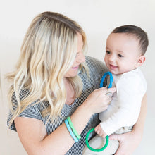 Load image into Gallery viewer, A woman smiles at a baby, wearing Bumkins Silicone Teething Rings 4 Pack: Summer while holding another.