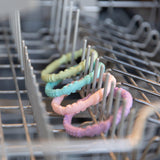 Bumkins Silicone Teething Rings 4 Pack: Spring sits in the top rack of an open dishwasher.