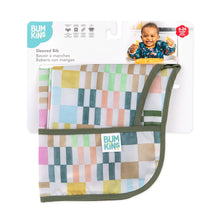 Load image into Gallery viewer, Bumkins Sleeved Bib: Motley Check is shown folded in its packaging.