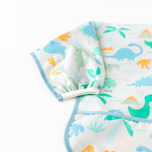 Load image into Gallery viewer, Close-up of Bumkins Sleeved Bib: Dinosaurs on a white background with focus on the elastic cuff on the sleeve.
