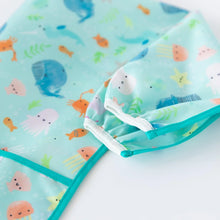 Load image into Gallery viewer, Close-up of Bumkins Sleeved Bib: Ocean Life on a white background, with focus on the white elastic cuff on the sleeves.