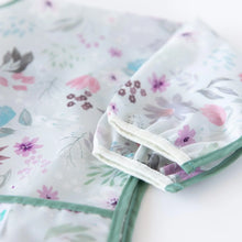 Load image into Gallery viewer, Close-up of Bumkins Sleeved Bib: Floral folded neatly on a white background, with focus on the white elastic cuff on the sleeves.