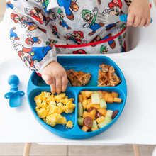 Load image into Gallery viewer, Close-up of a child in a colorful bib reaching for breakfast food from a blue plate next to a Bumkins Silicone Chewtensils®: Dark Blue.
