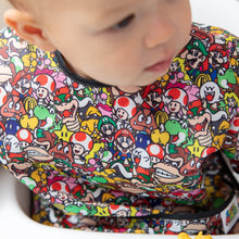 Load image into Gallery viewer, Close-up of a child wearing a Bumkins Sleeved Bib: Super Mario™ Mashup.