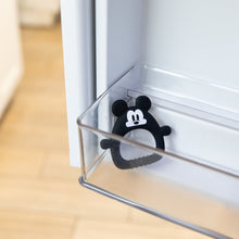 Load image into Gallery viewer, Bumkins Silicone Flat Teether: Mickey Mouse sits in the side compartment of an open refrigerator door.