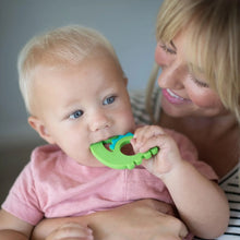 Load image into Gallery viewer, A woman cradles a toddler nibbling on a Bumkins Silicone Teether: Dinosaur.