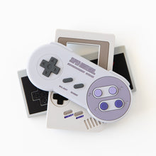 Load image into Gallery viewer, Bumkins Silicone Teether: Nintendo SNES™ Controller sits on top of other similar teethers on a white background.