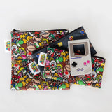 Bumkins Silicone Teether: Game Boy™ sits on top of a stack of video game-themed pouches on a white background.