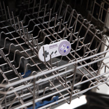 Load image into Gallery viewer, Bumkins Silicone Teether: Nintendo SNES™ Controller sits in the top rack of an open dishwasher.