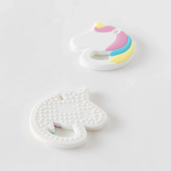 Two Bumkins Silicone Teether: Unicorn sit on a white background; one is face-down, showcasing sensory bumps on the back.