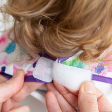 Load image into Gallery viewer, Close-up of adult hands adjusting the hook-and-loop closure of Bumkins Junior Bib: Watercolor around a child's neck.
