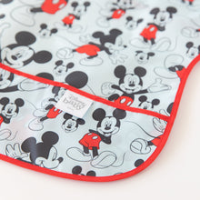 Load image into Gallery viewer, Close-up of Bumkins Junior Bib: Mickey Mouse Classic laid flat on a white background, with focus on the front pocket.