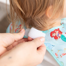 Load image into Gallery viewer, Adult hands adjust the hook-and-loop closure of Bumkins Junior Bib: Ariel around a child's neck.