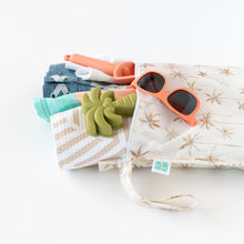 Load image into Gallery viewer, Bumkins Wet Bag: Palm Daze holds sunglasses, a toy palm tree, and beach items against a white background.