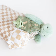 Load image into Gallery viewer, Roamio by Bumkins Wet Bag: Sand Check holds a rolled blanket, green pacifier, clothes, and plush turtle on a white background.