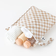 Load image into Gallery viewer, Roamio by Bumkins Wet Bag: Sand Check lays open on a white background with a towel and bottles inside.