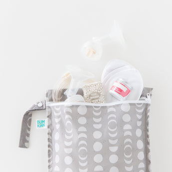 Bumkins Wet Bag: Lunar Phase is shown on a white background holding breast pump parts, nursing pads, and more.