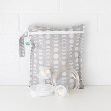 Load image into Gallery viewer, Bumkins Wet Bag: Lunar Phase is shown against a white brick background with breast pump parts in front.