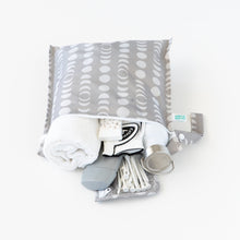 Load image into Gallery viewer, Bumkins Wet Bag: Lunar Phase is open on a white background, holding essentials like a towel, deodorant, bottle, and cotton swabs.