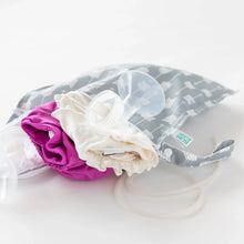 Load image into Gallery viewer, Bumkins Wet Bag: Arrow filled with cloth diapers and breast pump parts lays on a white background.