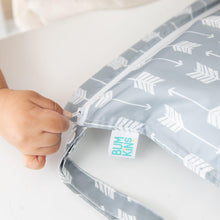 Load image into Gallery viewer, Close-up of a child zipping a Bumkins Wet Bag: Arrow on a white table.