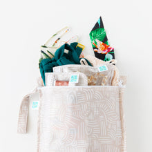 Load image into Gallery viewer, Bumkins Wet Bag: Wander holds matching pouches and colorful swimwear on a white background.