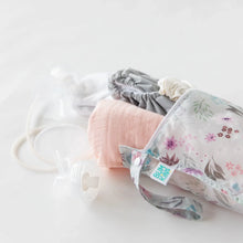 Load image into Gallery viewer, Bumkins Wet Bag: Floral lays on a white background with a nursing cover, cloth diapers, & breast pump parts spilling out.
