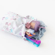 Load image into Gallery viewer, Bumkins Wet Bag: Floral lays open on a white background with a tumbler, clothes, toys, and toiletries inside.