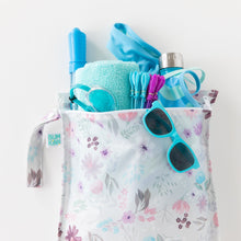 Load image into Gallery viewer, Bumkins Wet Bag: Floral holds a towel, goggles, sunglasses, swimsuit, and swim toys on a white background.