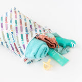 Bumkins Wet Bag: Mickey & Friends Varsity is shown on a white background holding a pacifier, folded towel, clothing, and sunscreen.