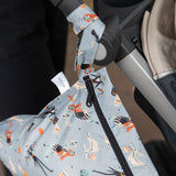 Close-up of a stroller with Bumkins Wet Bag: No Tricks, Just Treats, featuring Halloween ghosts and pumpkins, hanging from the handle.