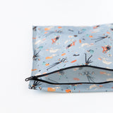Bumkins Wet Bag: No Tricks, Just Treats lays unzipped on a white background, revealing its interior.