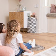 Load image into Gallery viewer, Children sit on a rug with books, facing a cabinet with Bumkins Extra Large Wet Bag: Charcoal Check holding stuffed animals nearby.
