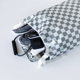 Bumkins Extra Large Wet Bag: Charcoal Check opens to reveal sneakers, phone, and gym gear spilling onto a white background.