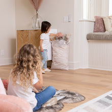 Load image into Gallery viewer, A child plays near a Bumkins Extra Large Wet Bag: Wander, filled with stuffed animals, while another child sits on the floor in a cozy room.