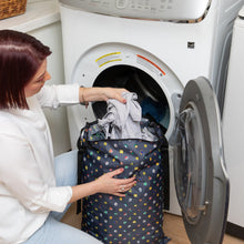 Load image into Gallery viewer, A person loads clothes from a Bumkins Extra Large Wet Bag: Super Mario™ Lineup into an open front-loading washing machine.