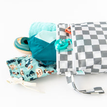 Load image into Gallery viewer, Bumkins Wet/Dry Bag: Charcoal Check with beach essentials on a white background: fun-pattern swim trunks, teal towel, swim shoes, and goggles.