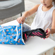 Load image into Gallery viewer, A child places a soccer cleat into a blue Bumkins Wet/Dry Bag: Mickey & Friends Forever on a white table.
