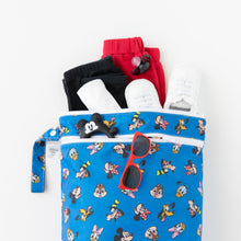 Load image into Gallery viewer, Bumkins Wet/Dry Bag: Mickey & Friends Forever holds red and black clothes, white shoes, and red sunglasses on a white background.