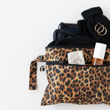 Load image into Gallery viewer, Roamio by Bumkins Wet/Dry Clutch: Leopard is partially out of frame on a white background, holding clothes, jewelry, tissues, and makeup.