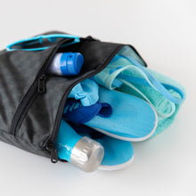 Load image into Gallery viewer, Roamio by Bumkins Wet/Dry Clutch: Rich Black lays open on a white background, holding a blue bottle, shoes, towel, swimsuit, and sunglasses.
