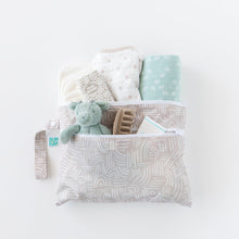 Load image into Gallery viewer, Bumkins Wet/Dry Clutch: Wander holds a stuffed dragon, clothes, hair clip, and wipes on a white background.