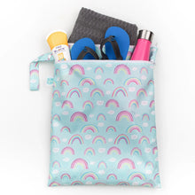 Load image into Gallery viewer, Bumkins Wet/Dry Bag: Rainbows holds flip-flops, a towel, sunscreen, and a pink water bottle on a white background.
