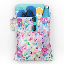 Load image into Gallery viewer, Bumkins Wet/Dry Bag: Watercolor holds shoes, a towel, a water bottle, sunscreen, and sunglasses on a white background.